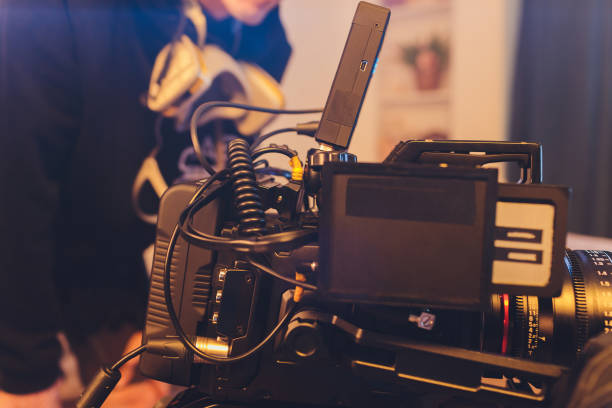 istock Video operator shoots on camera. Video camera with a transmitting device over Wi-Fi. Video production. Videographer in headphones. Video stream. 1255814412