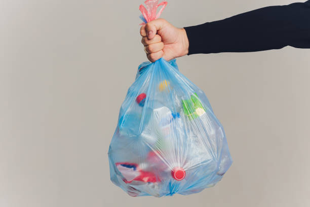 istock Man hands holding garbage bag isolated on white background. 1255814426
