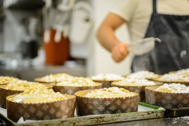 istock Chef baker adding sugar preparing panettone italian  cake in bakery 1255815238