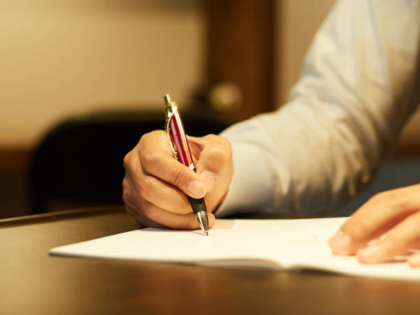 un homme d’affaires masculin signant un document. - desk writing business human hand photos et images de collection
