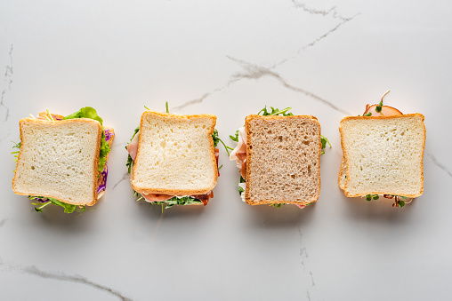 top view of fresh sandwiches on marble white surface