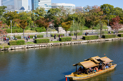 The skyline view on clear autumn day, as seen from Osaka Castle.  tourists use a vessel to visit the castle, via a moat surrounding the venue.