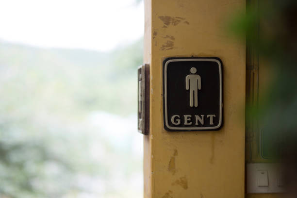 Purple and white all gender, gender neutral and accessible restroom sign with Braille code on an interior building wall..