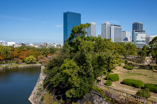 The skyline view on clear autumn day, as seen from Osaka Castle.  Office buildings tower in the background.  The moat surrounds the grounds of the castle.