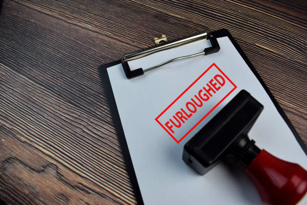 istock Red Handle Rubber Stamper and Furloughed text isolated on the table. 1255828646