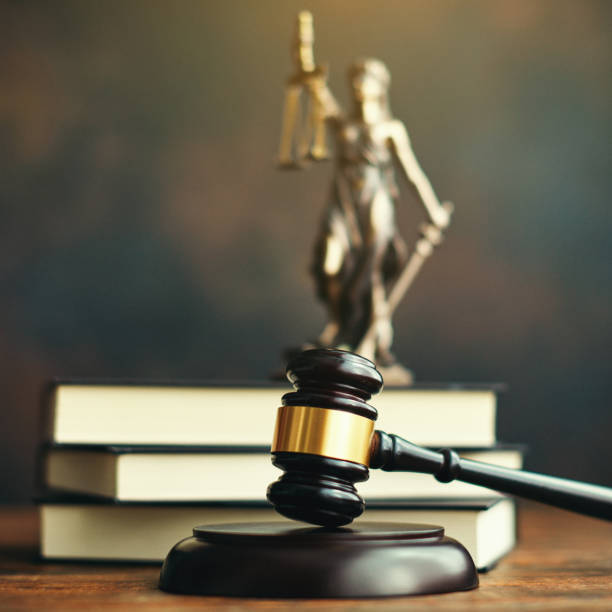 istock Gavel on desk with law books and Lady Justice 1255829558