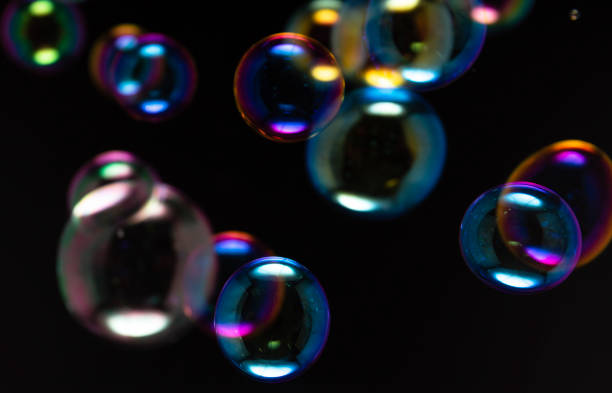 istock Colorful of rainbow soap bubbles float on black background. 1255830395