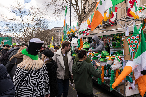 London, UK - Mar 17, 2019:  People buying oversized hats at the St Patrick's Day Parade and Festival at Trafalgar Square early in the day.