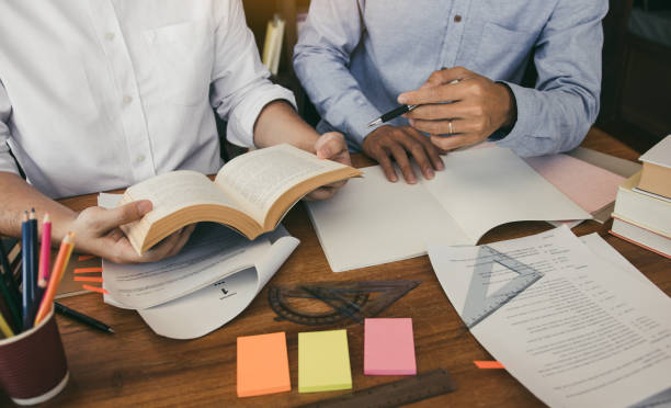istock Teenage student works on homework in his room and writing in notebook. 1255836310