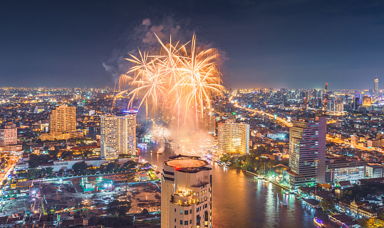Celebration firework new year skyscrapers and small traffic routes along the Chao Phraya River in Bangkok as seen from the Taksin Bridge at night. Bangkok,
