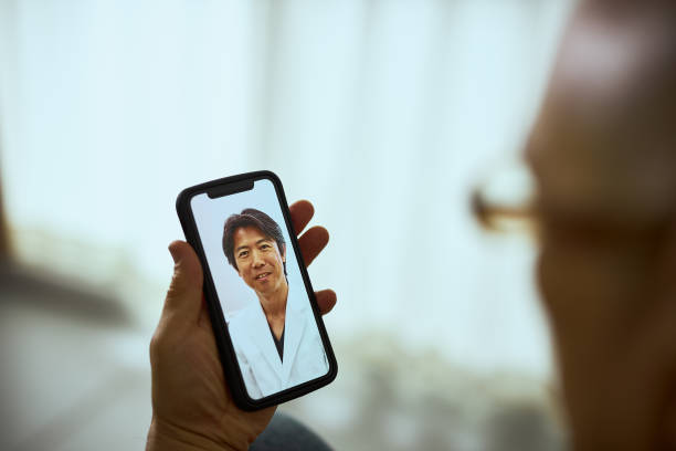 高齢者向け遠隔医療 - オンライン診療 スマホ 日本人 ストックフォトと画像