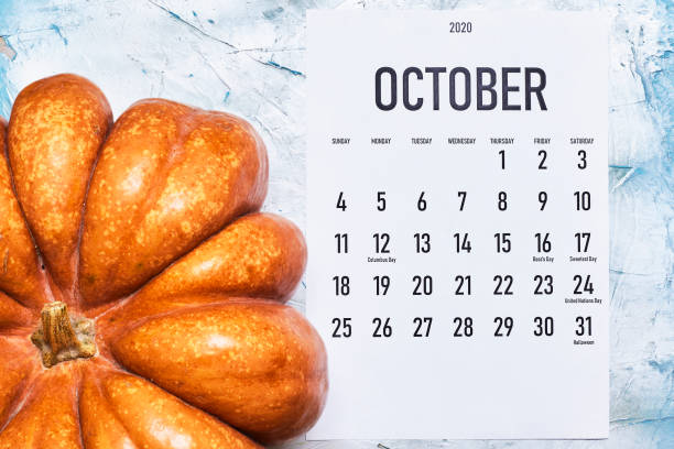 istock October 2020 monthly calendar with Pumpkin on wood 1255843384