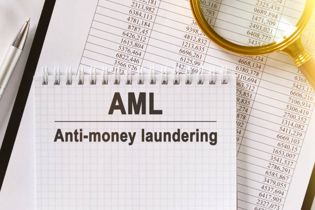 istock On the table are financial reports, a pen, a magnifying glass and a notebook with the inscription - AML. 1255843591