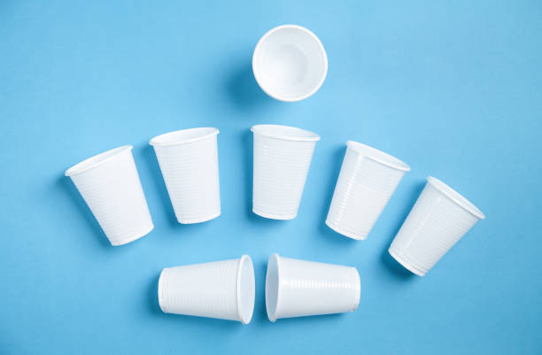 istock White transparent disposable plastic cups on the blue background. 1255846074