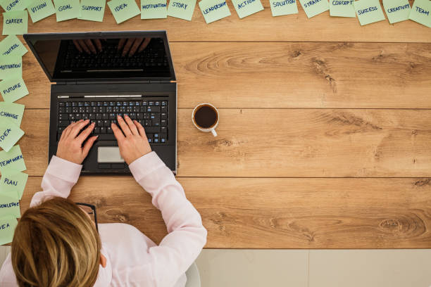 istock Copy space of businesswoman using laptop on a table with sticky notes with positive keywords written on them 1255850700