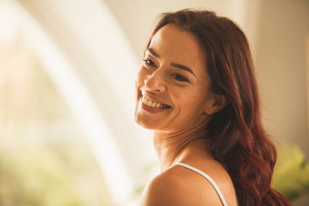 istock Smiling woman looking over the shoulder and contemplating 1255851728