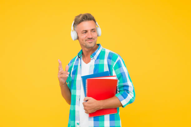 istock Audio courses. Learning english. Modern technology. Audio book concept. Worldwide knowledge access. Audio library. Man handsome student wear headphones hold books. Study languages. Free courses 1255853251