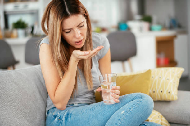 istock Girl taking medicine pill for a cold. 1255853742