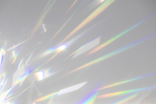 Blurred rainbow light refraction texture on white wall