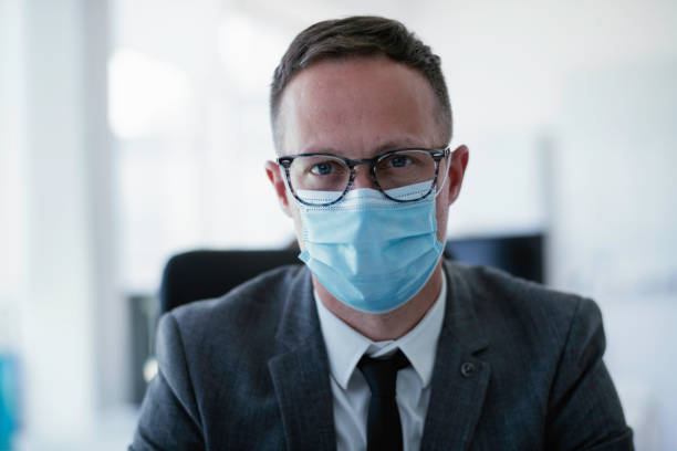 istock Businessman with medical mask working in office. 1255853969
