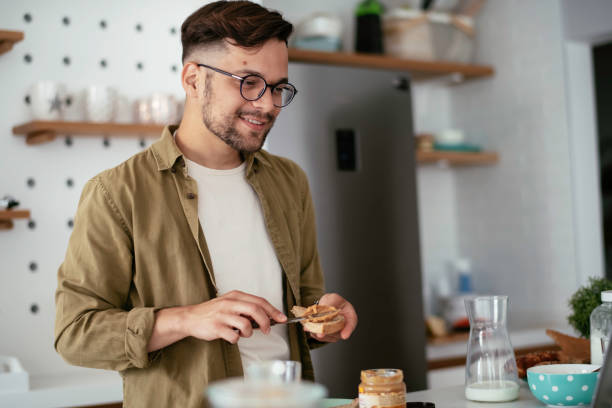 istock Young man eating breakfast and reading the news online. 1255854006