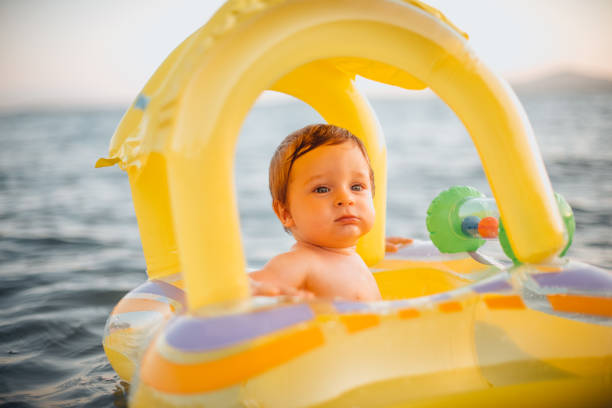 istock Baby Playing With Inflatable Ring in the Sea 1255854051