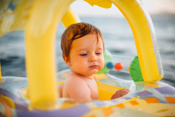 istock Baby Playing With Inflatable Ring in the Sea 1255854053