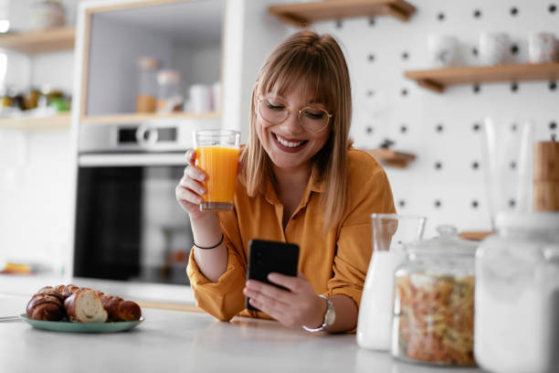 istock Beautiful woman drinking orange juice in the kitchen. 1255854963