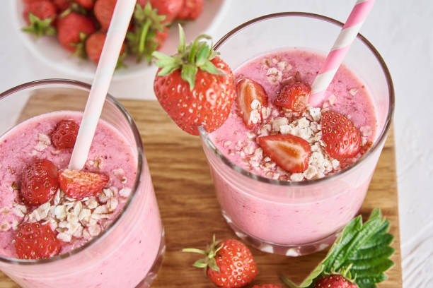 istock Strawberry milk shake in glass with straw and fresh berries on a white background 1255857708