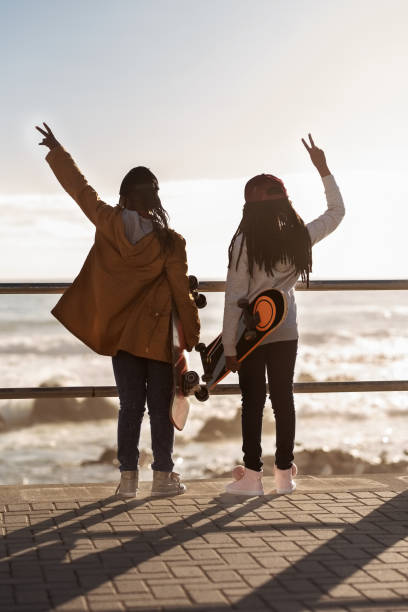 istock Girls with skateboards enjoying the sunset view 1255858894