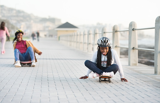 Shot of two little girls having fun with skateboards on the promenade