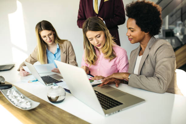istock Group of businesspeople working on laptop computer and discussing 1255858991