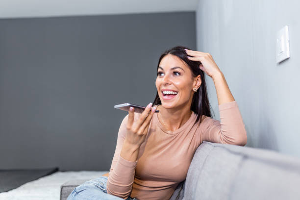 istock Woman laughing while talking on speakerphone. technology, communication and people concept - happy woman using voice command recorder on smartphone 1255864826