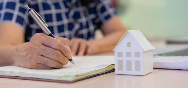 de cerca mujer senior escribiendo a mano en el cuaderno sobre el plan de jubilación y las finanzas de la casa para gestionar los gastos e invertir en el banco para el concepto de vida madura - retirement investment capital letter text fotografías e imágenes de stock