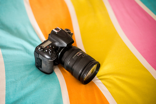 A modern DSLR camera on a colorful background