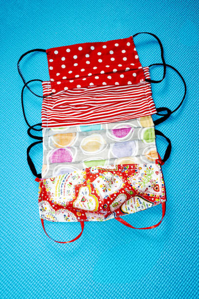 istock Isolated Colorful Home Made, Face, Protective Masks on a Blue Background. 1255868808