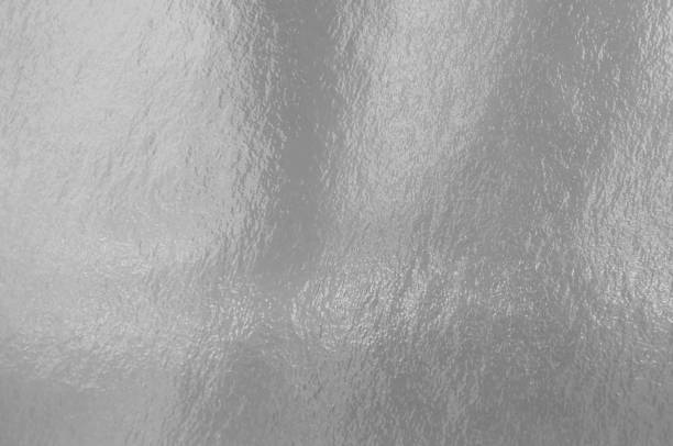 istock Silver foil texture background with highlights and uneven surface 1255869494