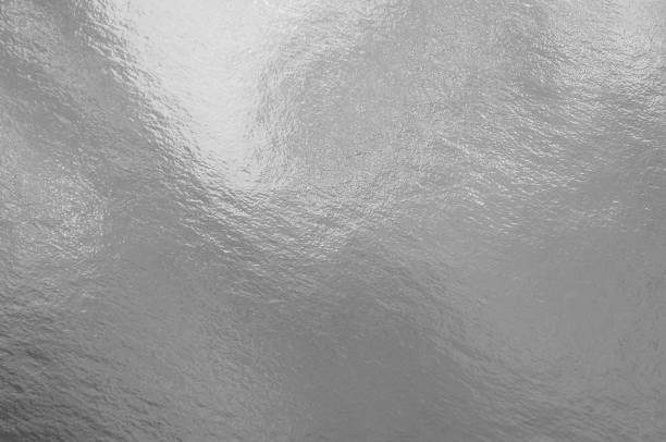 istock Silver foil texture background with highlights and uneven surface 1255869516