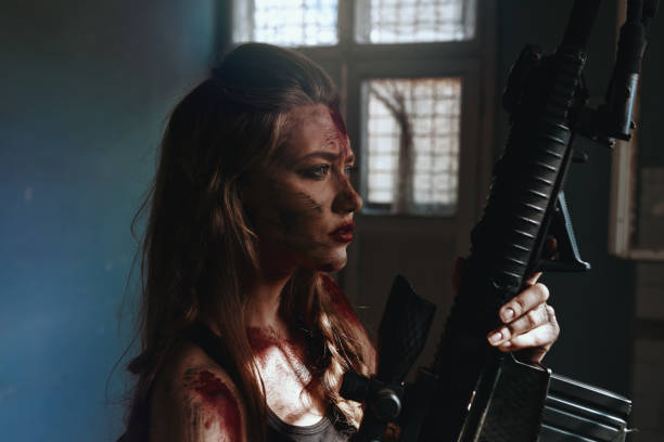 istock Woman covered in blood holding rifle 1255870632