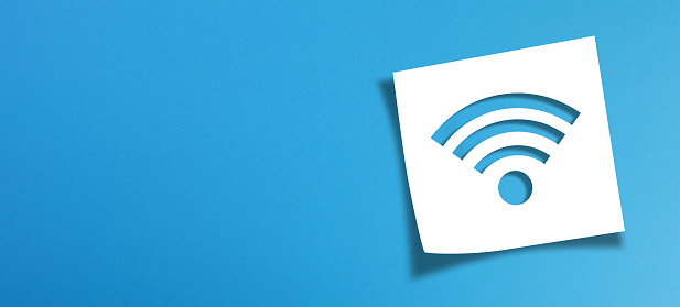 Note paper and wifi sign with copy space on panoramic blue background
