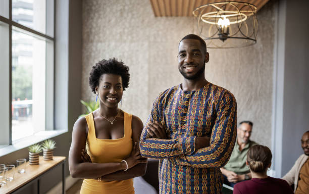 istock Two young African businesspeople standing together in an office 1255873649