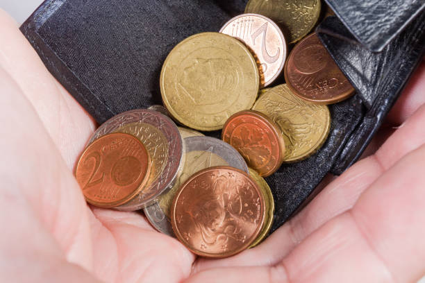 istock Coins poured from the wallet in hand palm close-up 1255873988