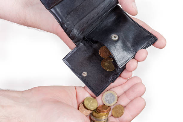 istock Coins poured from the old wallet into the hand palm 1255874004