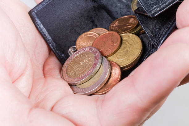 istock Handful of coins poured from wallet, closeup in selective focus 1255874025