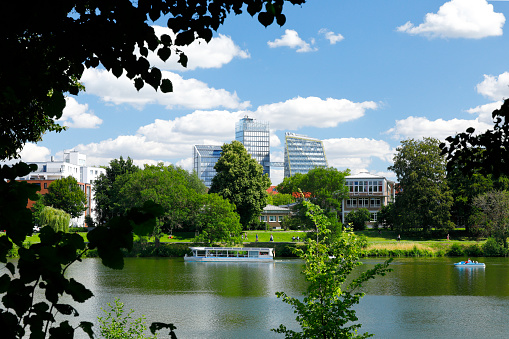 The Aasee in Münster in midsummer. Modern administration buildings in the background.