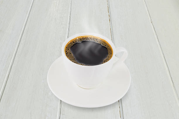 istock White coffee cup on white vintage wooden tabletop background 1255879277
