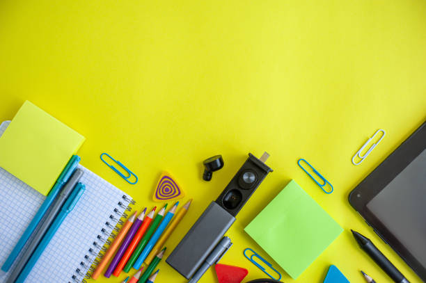 istock Back to school. Distance learning. Stationery with a tablet on a yellow background. Flat lay. Copy space. 1255880586