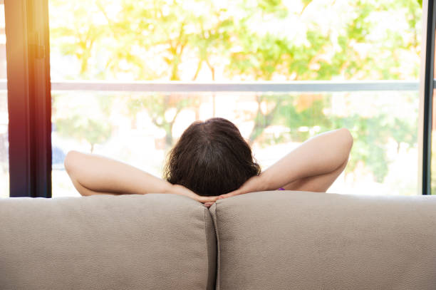 istock woman relaxing looking outside through a window 1255880974
