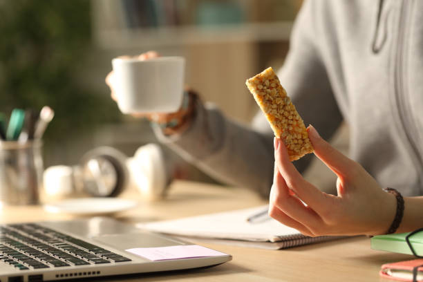 istock Student hands holding coffee and bar at night studying 1255881318