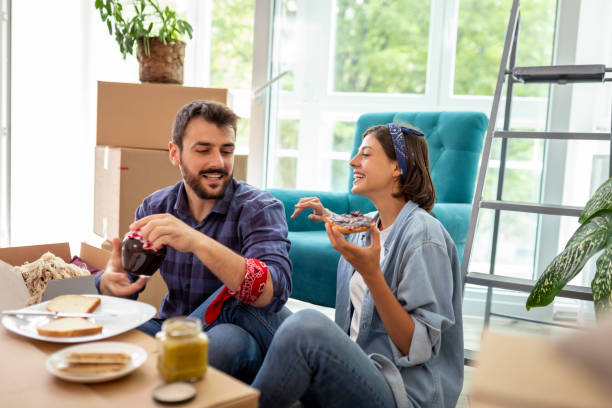 istock Couple having breakfast while moving in new apartment 1255885373